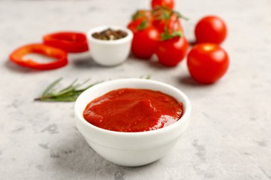 Arka planda leziz domates ezmesi olan bir kase.