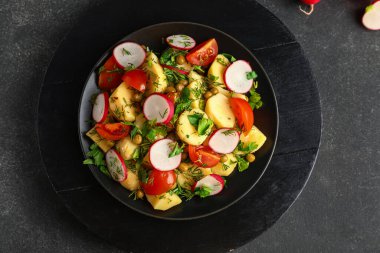 Sebzeli ve koyu arkaplanlı lezzetli patates salatası.