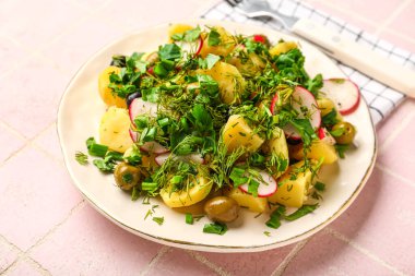 Pembe fayanslı sebzeli patates salatası.