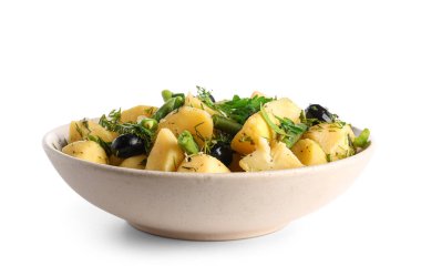 Beyaz arka planda sebzeli bir kase lezzetli patates salatası.