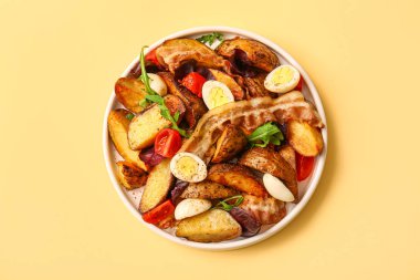 Bej arka planda yumurta, domates ve domuz pastırmalı lezzetli patates salatası.