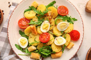 Hafif arka planda yumurta ve domatesli lezzetli patates salatası.