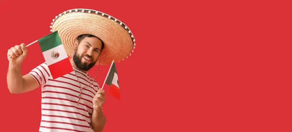 ソンブレロのハンサムな男とテキストのためのスペースと赤の背景にメキシコの旗 — ストック写真