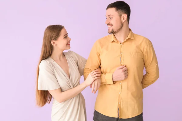 可爱的年轻夫妇手牵手在紫丁香背景上散步 — 图库照片