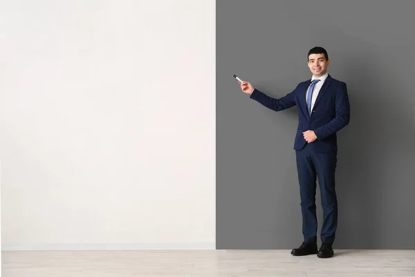 Business consultant with marker near black and white wall
