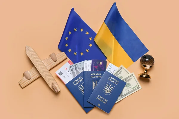 Paszporty Pieniędzmi Zabawkowy Samolot Flagi Ukrainy Unii Europejskiej Beżowym Tle — Zdjęcie stockowe