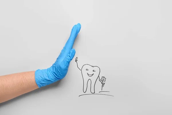 Tıbbi Eldivenli Bir Dişçi Arka Planda Bir Diş Çizmiş — Stok fotoğraf