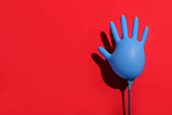 Inflated medical glove on red background