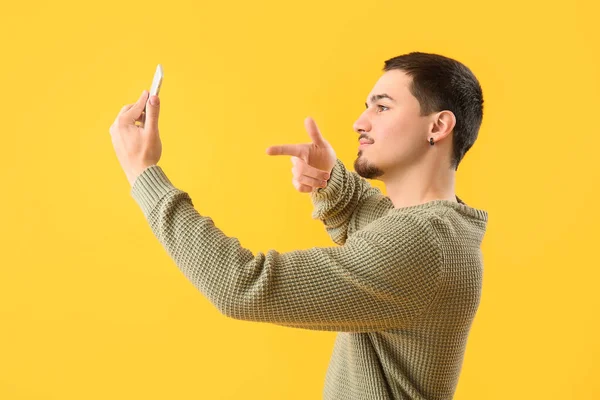 Fajny Młody Człowiek Smartfonem Robiącym Selfie Żółtym Tle — Zdjęcie stockowe