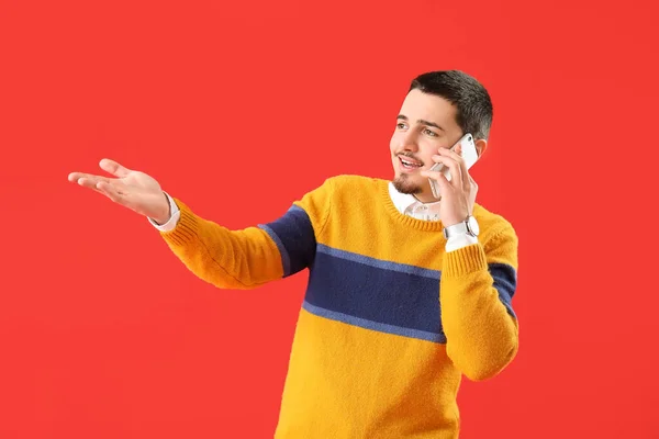 Przystojny Młody Człowiek Rozmawia Przez Telefon Czerwonym Tle — Zdjęcie stockowe