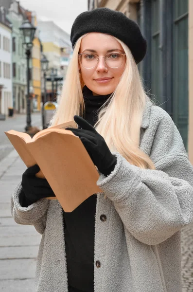 在城市街道上读书的年轻女人 — 图库照片
