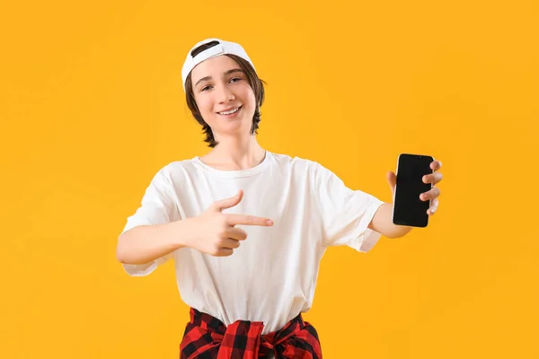 Cooler Teenager Zeigt Auf Handy Auf Gelbem Hintergrund — Stockfoto