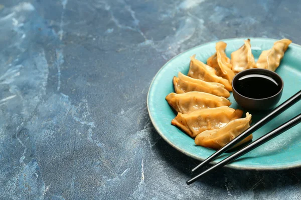 Teller Mit Leckerem Chinesischem Jiaozi Und Sauce Auf Blauem Hintergrund — Stockfoto