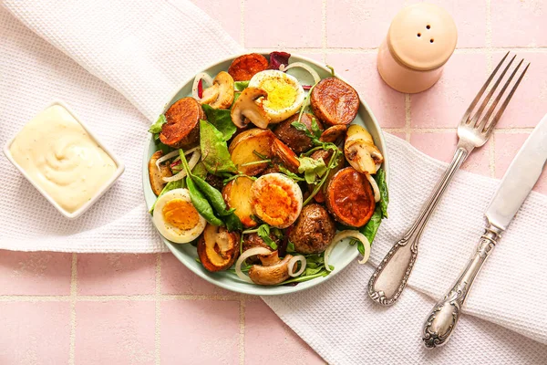 stock image Plate of tasty potato salad with eggs and mushrooms on light pink background, top view