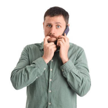 Tırnak yiyen ve beyaz arka planda cep telefonuyla konuşan yakışıklı bir adam.