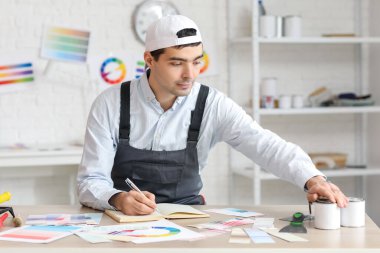 Masada deftere yazı yazan erkek ressam.