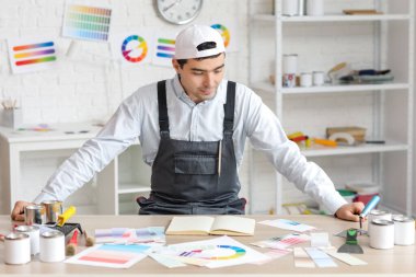 Masanın yanındaki erkek ressam.