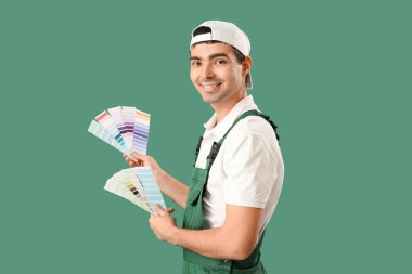 Male painter with color palettes on green background