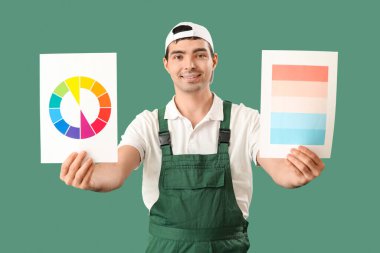 Male painter with color palettes on green background