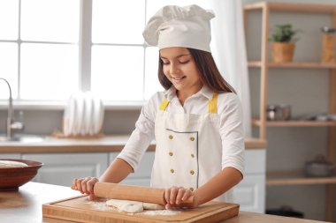 Küçük fırıncı mutfaktaki masaya hamur atıyor.