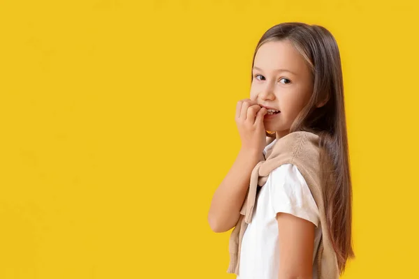Little Girl Biting Nails Yellow Background — Foto Stock