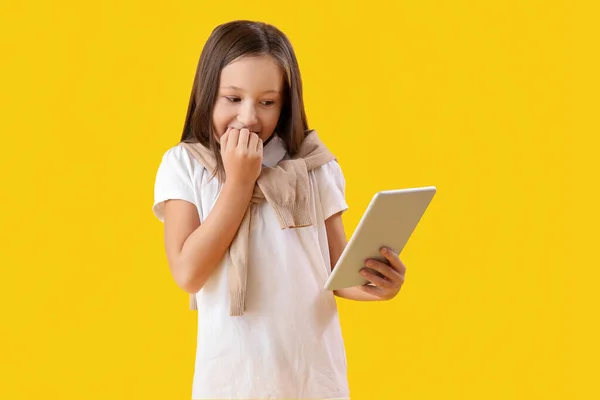 Little Girl Tablet Computer Biting Nails Yellow Background — Stock Photo, Image