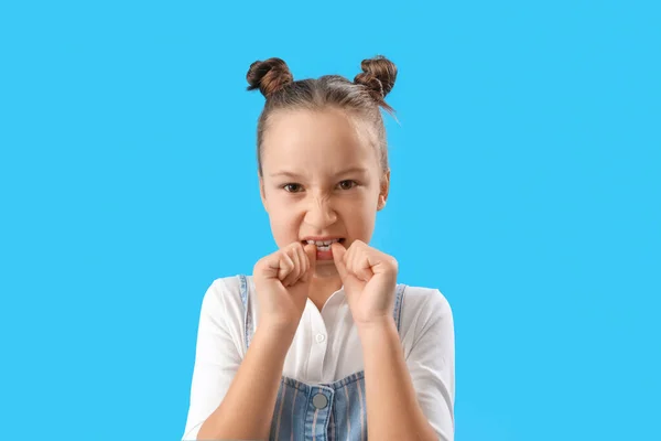 Little Girl Biting Nails Blue Background Closeup — Stockfoto