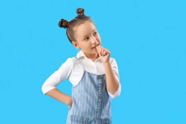 Little Girl Biting Nails Blue Background — Zdjęcie stockowe