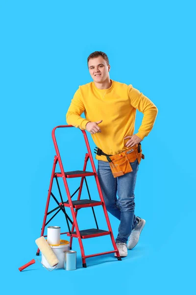 Young Man Ladder Cans Paint Blue Background — Stock Fotó