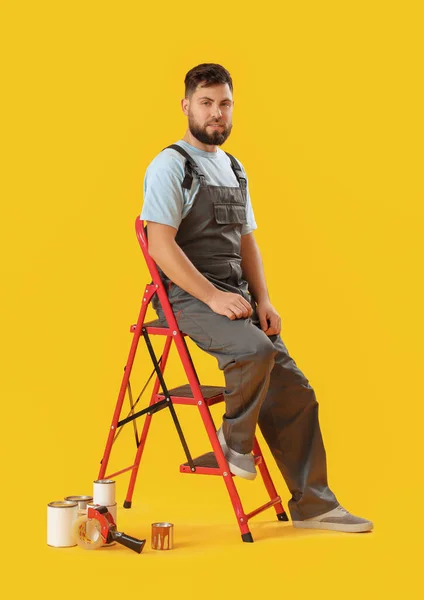 Male Worker Ladder Cans Paint Yellow Background — Foto Stock