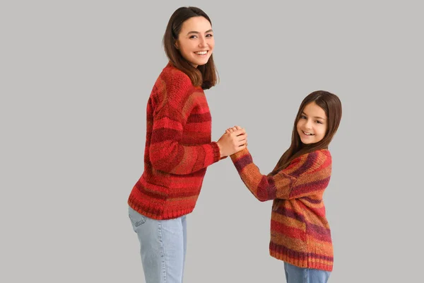 Dziewczynka Jej Matka Ciepłych Swetrach Trzymają Się Ręce Szarym Tle — Zdjęcie stockowe