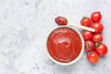 Beyaz grunge arka planda bir kase lezzetli domates ezmesi.