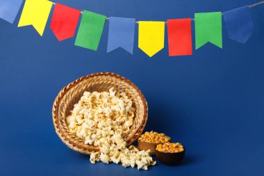 Patlamış mısırlı hasır şapka, mavi arka planda kaseler ve bayraklar. Festa Junina (Haziran Festivali) kutlaması