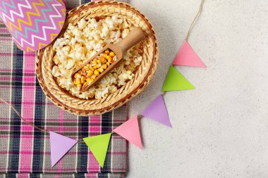 Patlamış mısırlı hasır şapka, parti konisi, bayraklar ve beyaz arka planda peçete. Festa Junina (Haziran Festivali) kutlaması