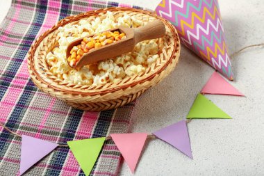 Patlamış mısırlı hasır şapka, parti konisi, bayraklar ve beyaz arka planda peçete. Festa Junina (Haziran Festivali) kutlaması