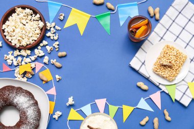 Festa Junina (Haziran Festivali) için geleneksel yiyecek ve bayraktan yapılmış çerçeve mavi arka planda