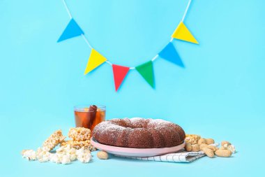 Festa Junina için geleneksel yiyecek ve bayraklar (Haziran Festivali) mavi arka planda