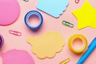 Pembe arka planda yapışkan notlar ve kırtasiye malzemesi