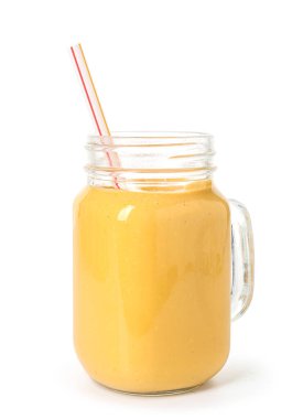 Mason kavanozu beyaz arka planda saman olan lezzetli sarı smoothie.