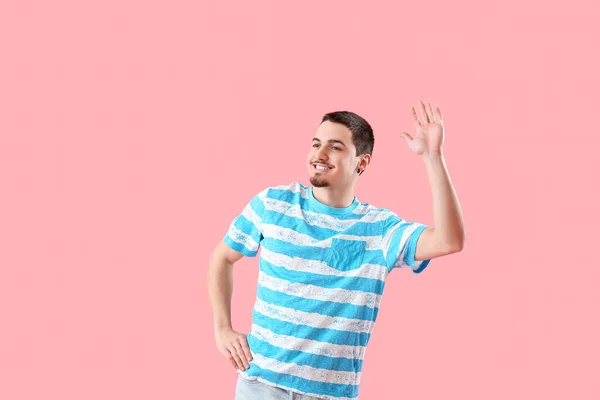 Schöner Junger Mann Winkt Mit Der Hand Auf Rosa Hintergrund — Stockfoto