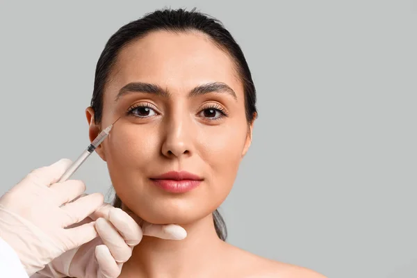 Young Woman Receiving Filler Injection Face Grey Background — Stock Photo, Image