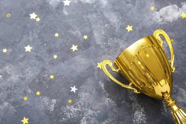 Gold cup with stars on dark background, closeup