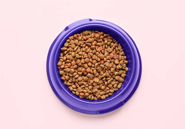 stock image Bowl with dry pet food on pink background