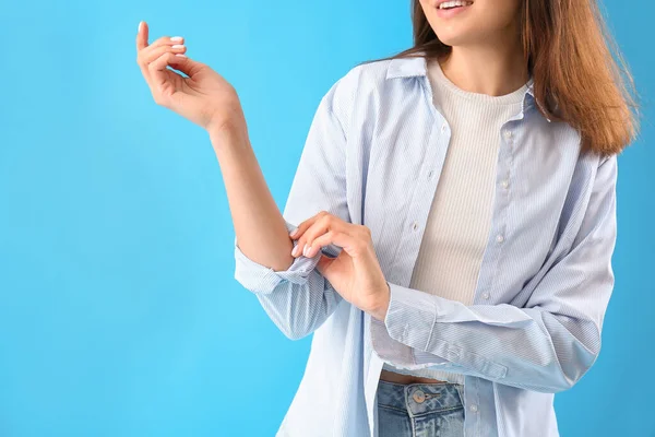 Young Woman Rolling Her Sleeve Light Blue Background — Stock Photo, Image