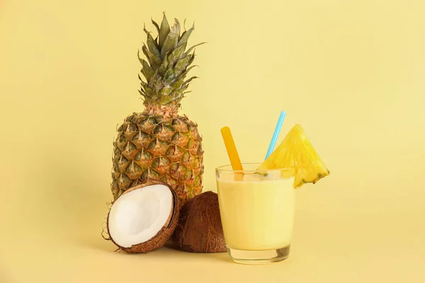 黄色の背景においしいパイナップルスムージー わらとココナッツのガラス — ストック写真