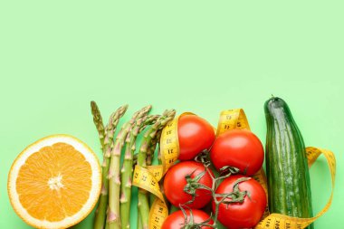 Sebzeler, yeşil arka planda limon ve sarı mezura. Diyet kavramı