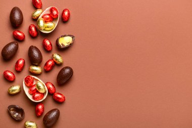 Kahverengi arka planda çikolatalı Paskalya yumurtası ve şekeri.