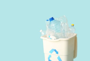 Açık mavi arka planda plastik olan çöp konteynırı. Geri dönüşüm kavramı