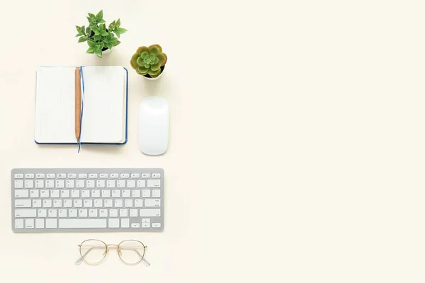Composition with notepad, keyboard, eyeglasses and plants on white background