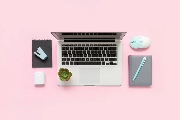 Composition with laptop, plant, notepad and mouse on pink background
